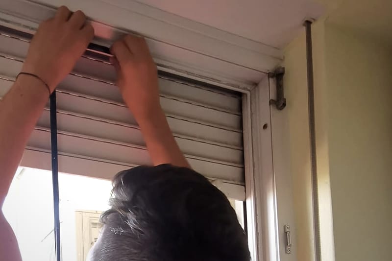 Tehnician care montează o garnitură nouă pe tocul unei uși.
