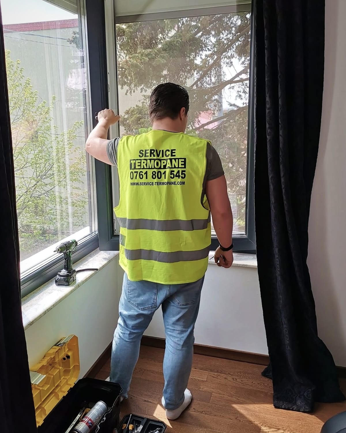 Tehnician la o fereastră antracit existentă.